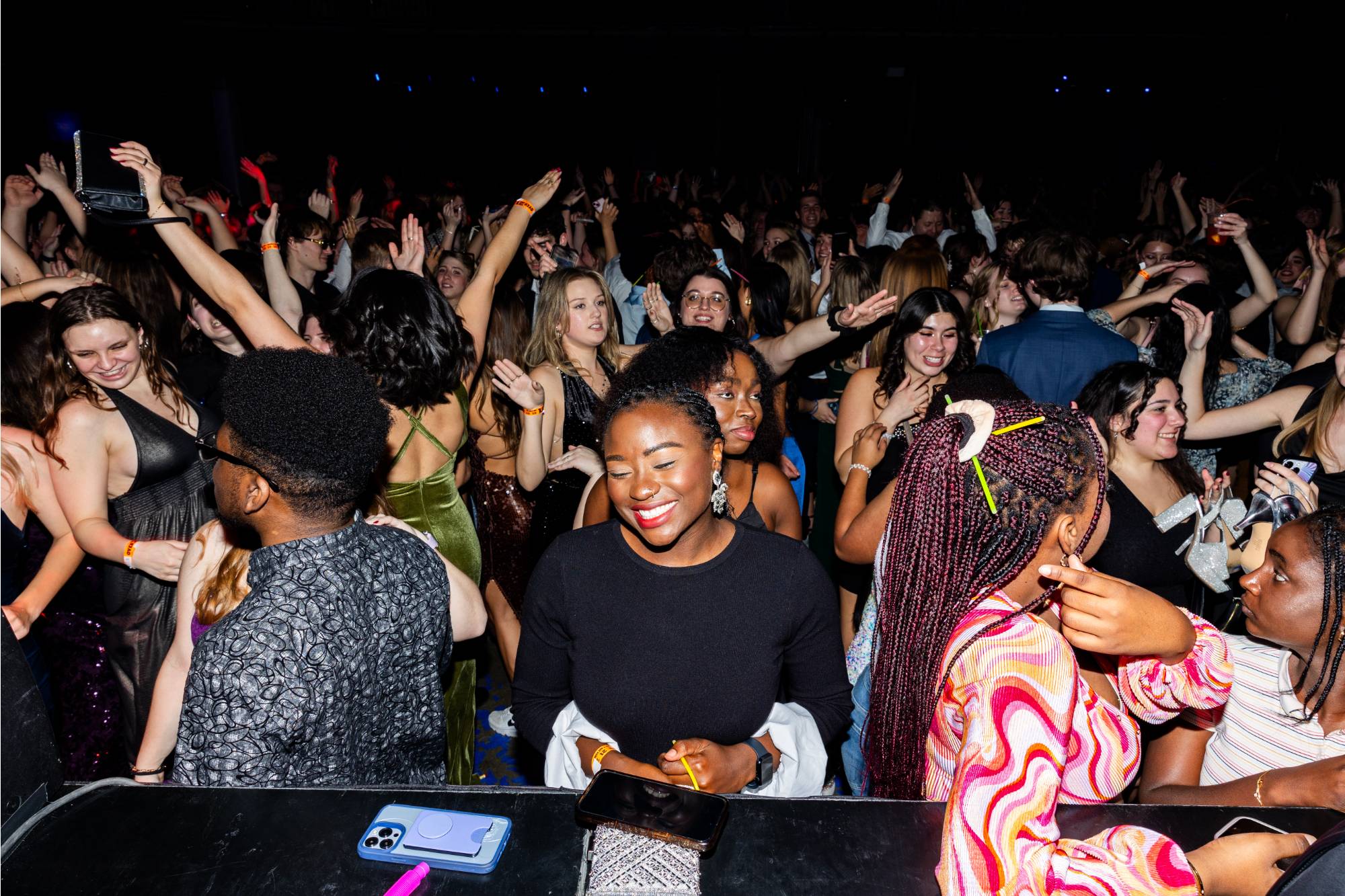 student smiling while other students dance behind her